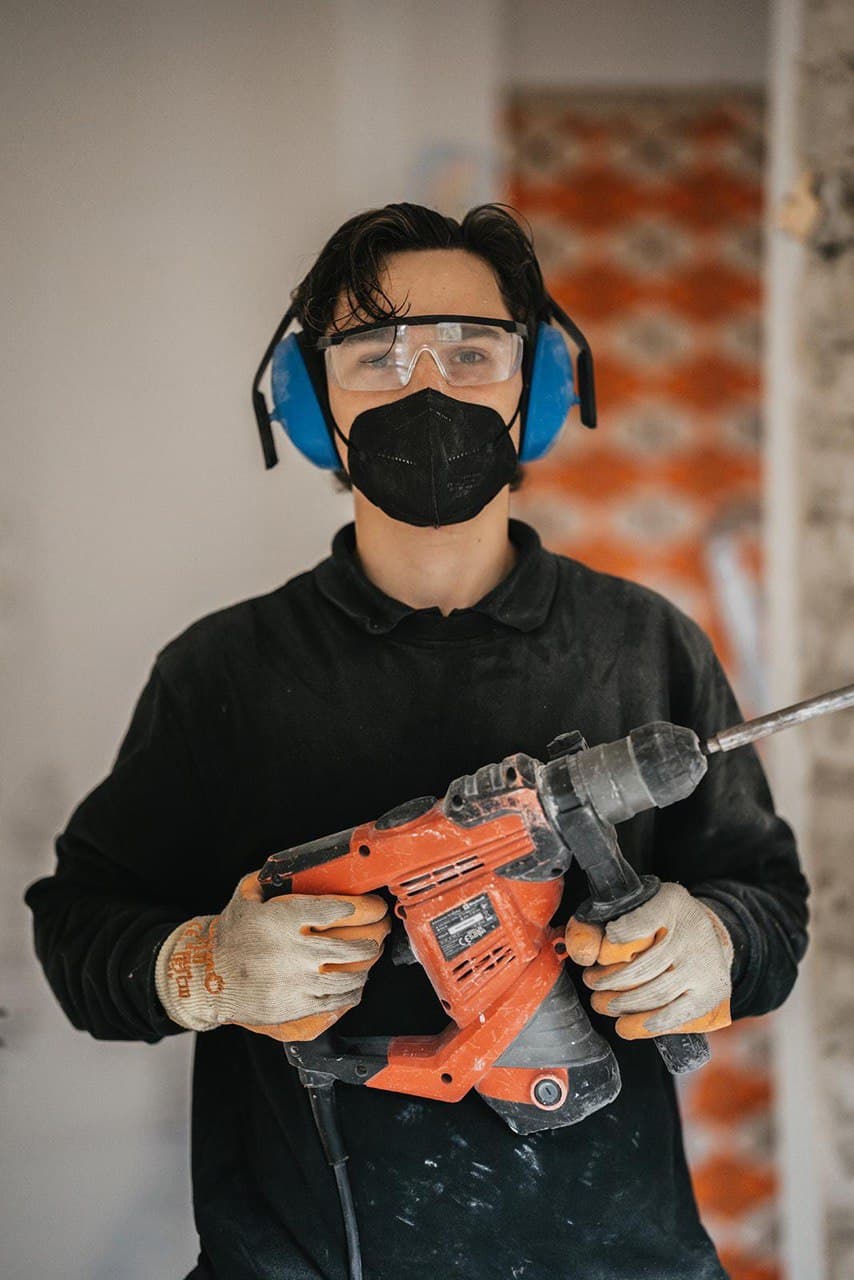 Mitarbeiter mit Bohrhammer bei der Arbeit